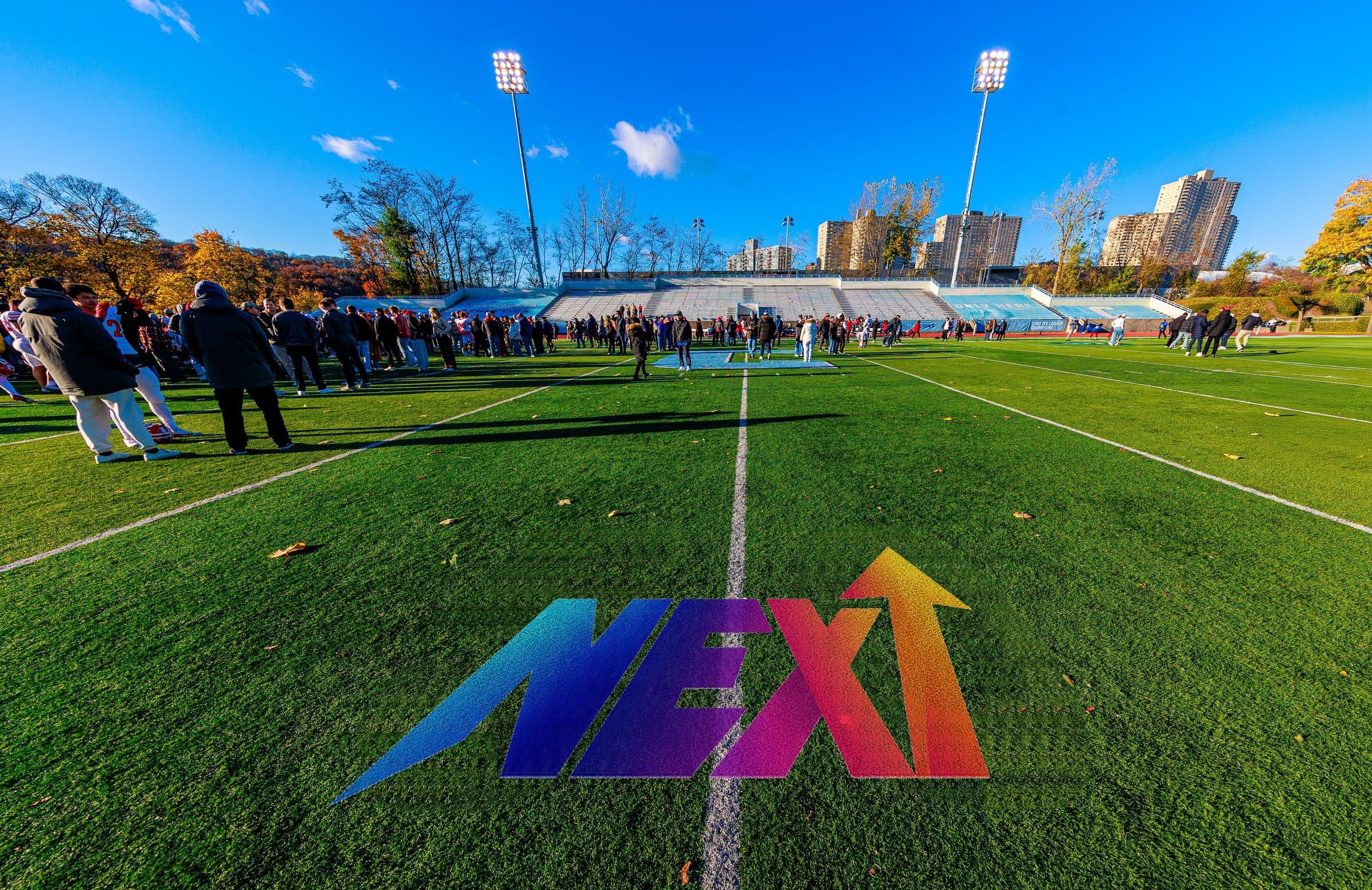 The NEXT UP logo painted on a turf football field